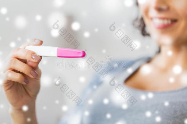 关闭快乐的女人与家庭怀孕测试