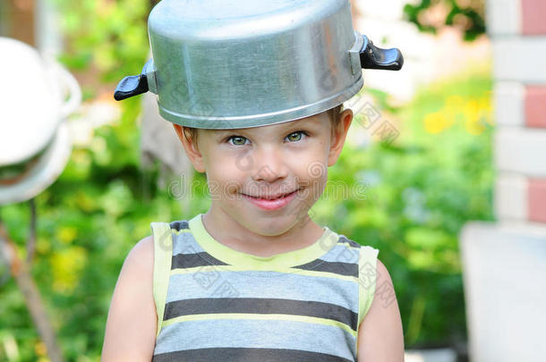 一个头上有平底锅的孩子。 带平底锅的孩子。 快乐的孩子放纵。 一个戴着平底锅帽子的孩子。