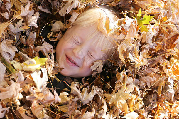 可爱的小孩子躺在一堆落叶里