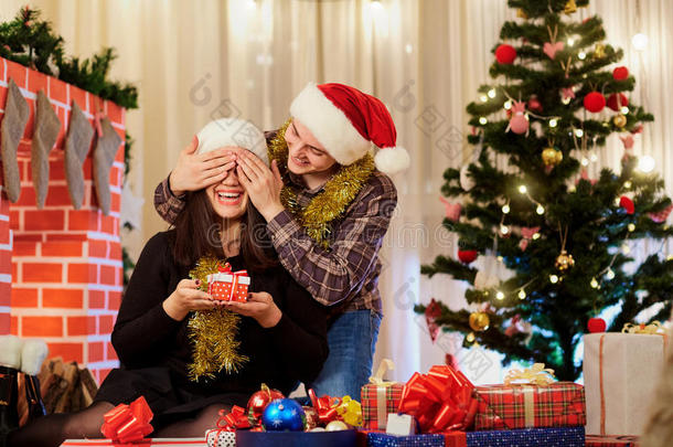 一对相爱的夫妇在圣诞节戴着帽子互相送礼物。 的