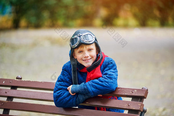 <strong>梦</strong>想<strong>飞翔</strong>。 一个孩子穿着复古的空气头盔和防护眼镜在公园里玩耍。
