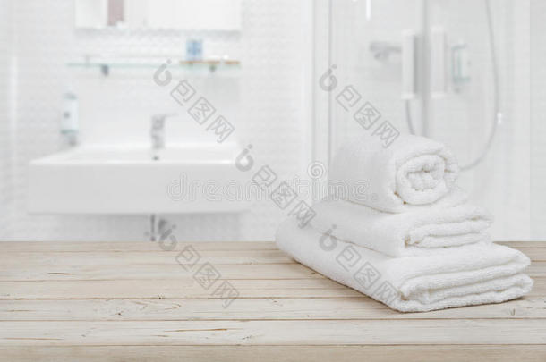 模糊的浴室内部背景和白色水疗毛巾在木材上