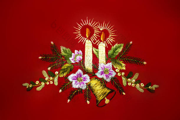 圣诞节用燃烧的蜡烛，铃铛和花，绣在红色的背景上