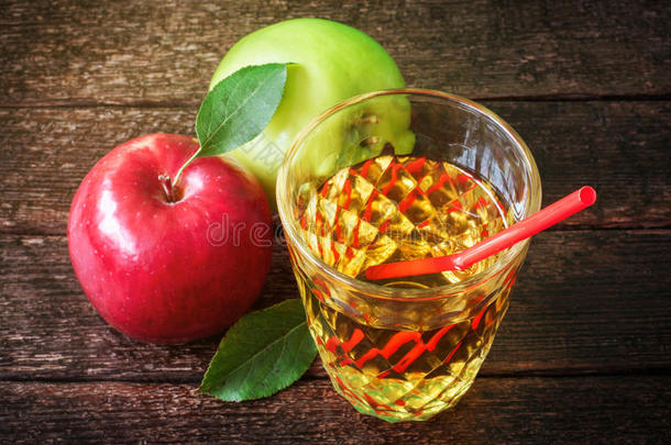 一杯苹果汁，背景是红色和绿色的苹果
