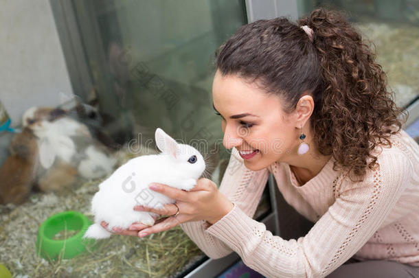 在<strong>宠物店</strong>抱着兔子的女孩