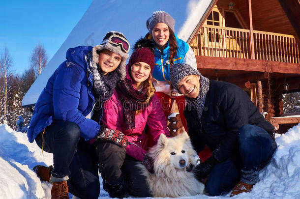 快乐的朋友和狗一起在山上的小屋度过寒假