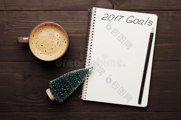 一杯咖啡和笔记本，目标为2017。计划和动机的新年概念。 上面的风景。