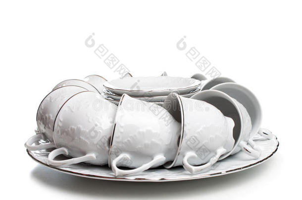 一套白色的盘子和杯子。 在杯子和盘子上温柔的图案。 从上面可以看到一套盘子。 十个杯子和D