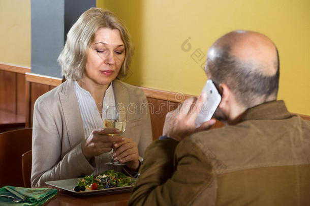 老妇人在<strong>餐馆</strong>里无聊，而她的男人在<strong>餐馆</strong>里说话