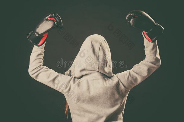 穿帽衫的拳击手向后站着，手臂在空中。