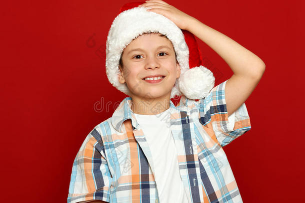 男孩儿童肖像在圣诞老人帽子上的红色，有乐趣和情感，寒假的概念