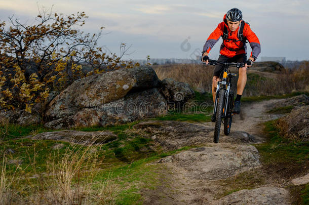 骑着红色<strong>夹克</strong>的自行车在岩石小径上骑自行车。 极限<strong>运动</strong>。