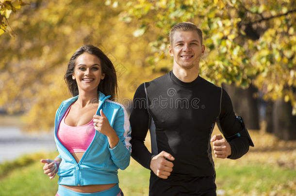 美丽的年轻夫妇在公园里<strong>一起跑</strong>步。