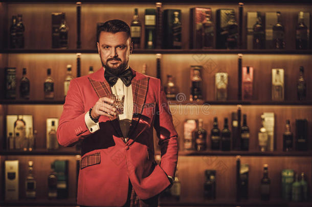 奢华时尚的男士在绅士俱乐部里用威士忌玻璃