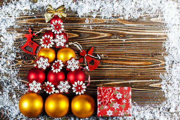 <strong>圣诞树</strong>，内衬红色和<strong>金色</strong>的<strong>圣诞树</strong>球。 <strong>圣诞树</strong>玩具躺在木头表面上。