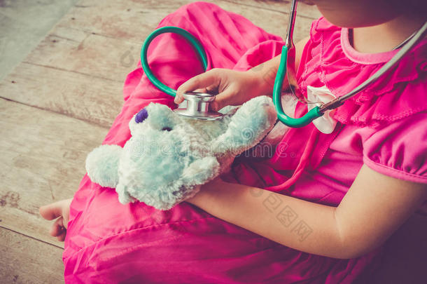 孩子在家里玩医生或护士和<strong>毛绒玩具熊</strong>。 复古色调效果。
