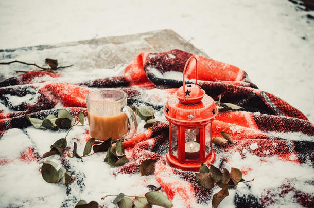 节日的红烛在灯笼和杯子咖啡在地毯上与雪