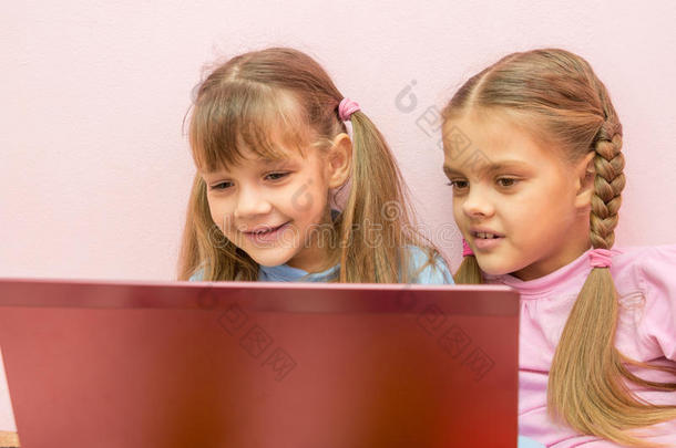 两个女孩看着笔记本电脑
