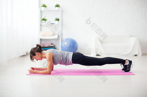 适合女孩在垫子上的木板位置在家客厅锻炼背部脊柱和姿势概念普拉提健身