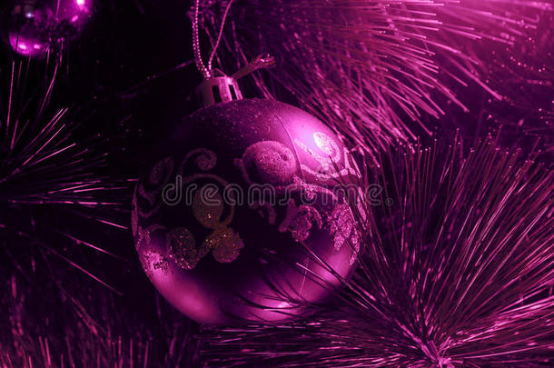 在装饰的圣诞树或抽象的新年球上挂着红色的手镯，表面光滑，红色栗色粉红色vi
