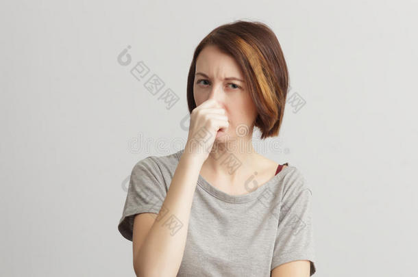 女孩因气味和恶臭而关闭鼻子。