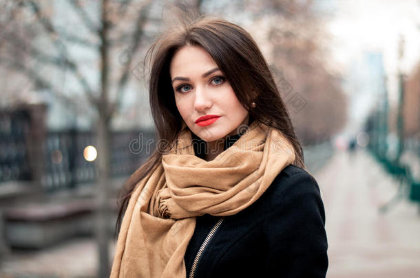 秋季时尚肖像年轻快乐的黑发女孩红色口红在城市户外