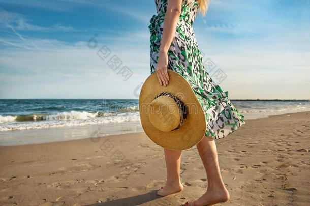 赤脚妇女在海边沙滩上散步，在热带岛屿的旅游中享受假期