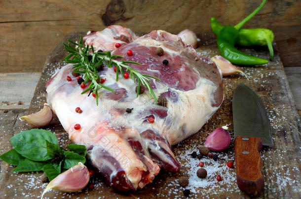 新鲜的生肉。 一条带有香料的羊肉腿放在木板上，用刀子烤、炖、皮拉夫、烧烤