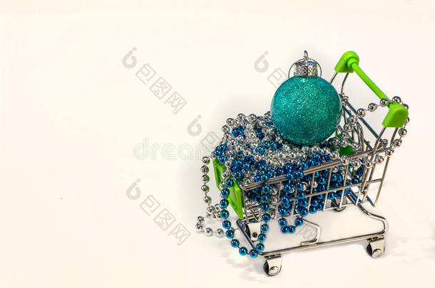 购物车与珠子和圣诞树玩具球。 买一份新年礼物。 买一份圣诞礼物。 买很多礼物。