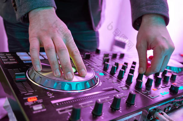 DJ在数字MIDI混频器控制器上播放和混合音乐。