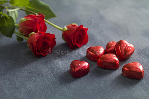 一束红玫瑰和哈特形状的巧克力。 情人节