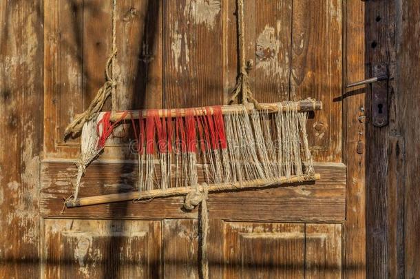 旧传统织布机和梭子在经纱上的细节。 在老式背景下为自制织布机织布。
