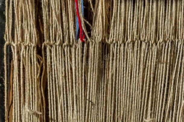 旧传统织布机和梭子在经纱上的细节。 在老式背景下为自制织布机织布。