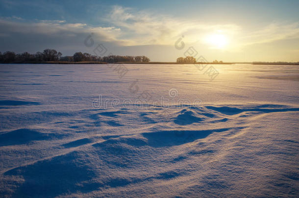 美丽的冬季景观与湖泊和日落的天空。