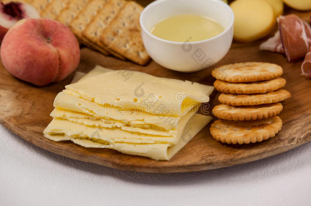 不同类型的奶酪，脆饼干，水果和酱汁在木板上
