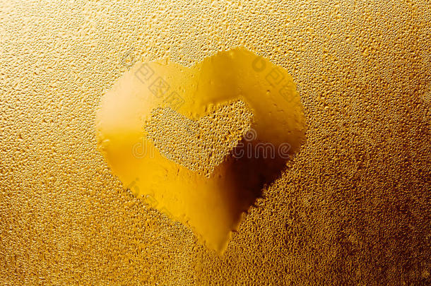 金色的爱心为情人节。 透明玻璃背景上的水滴图案，橙色抽象