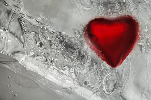 冰冻的爱心在冰中。 红色和霜质感图案。 情人节，寒冷的冬季天气背景。 宏