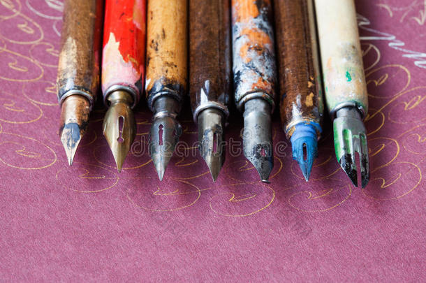 钢笔收藏。 书法配件，老年彩色艺术家笔，纹理粉红纸背景。 讲习班