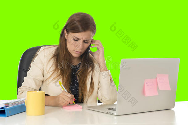 办公室电脑桌上的女商人在绿色<strong>彩屏</strong>上用手机交谈