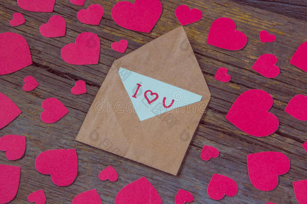 信封上有卡片和文字，我爱你，红色的心，为情人节的木制背景