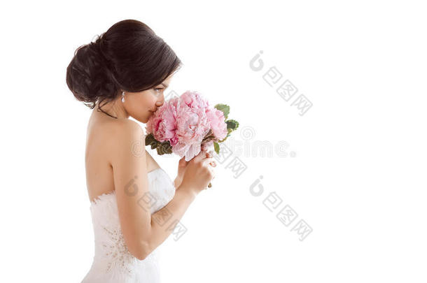 美丽的新娘带着她的花。 婚礼发型化妆豪华时尚礼服和花束
