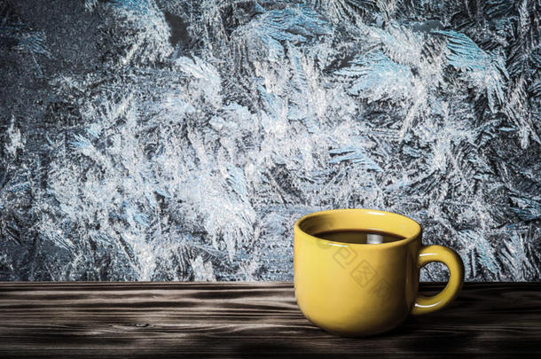 咖啡或茶在黄色的杯子在木桌上，相反的美丽的自然图案在磨砂玻璃上作为背景。 拼贴。
