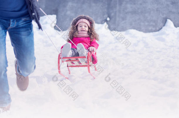 父亲和女儿在冬天的雪公园户外玩耍