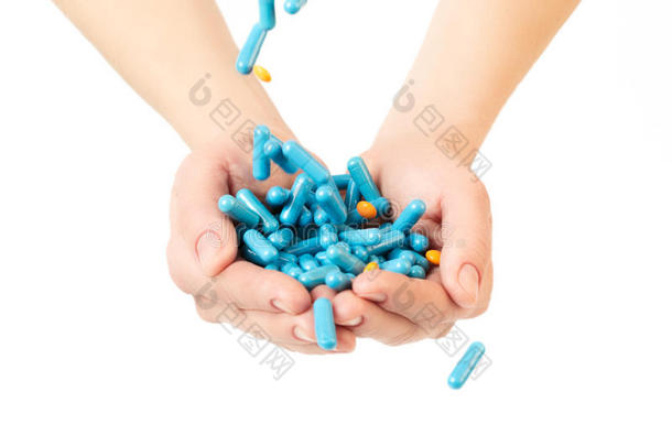 手在白色背景上给蓝色胶囊和橙色药丸。