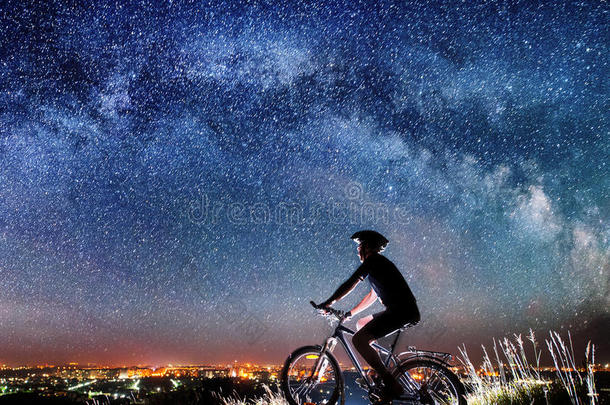 骑自行车的人在星空下的夜晚骑自行车