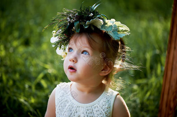 美丽的小女孩戴着绿色和白色的花环。 穿衣服，公主。