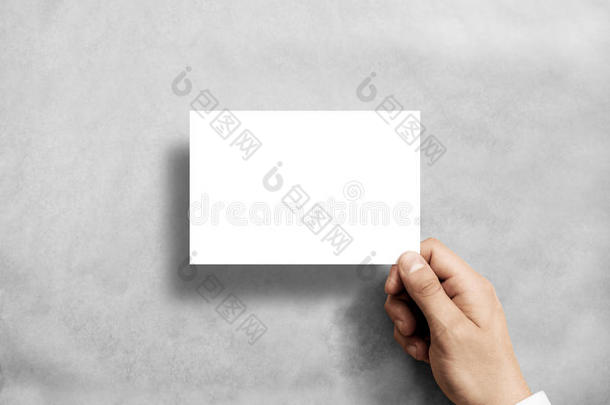 手里拿着空白的白色明信片传单。