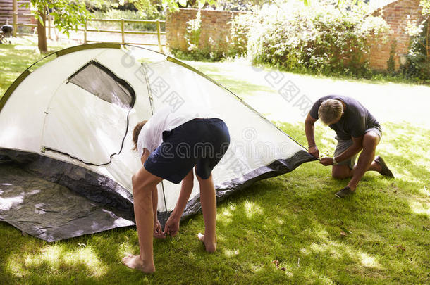 父亲和十几岁的儿子在野营旅行中<strong>搭帐篷</strong>