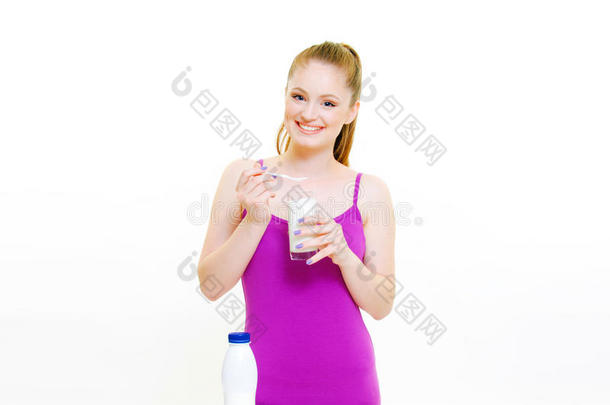 美丽的年轻女孩喝酸奶，牛奶和水果