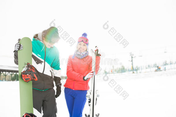 快乐的年轻夫妇，在雪地里滑雪板和滑雪板